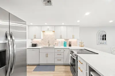 a kitchen with white cabinets and a stainless steel refrigerator at Pinnacle Port C1-401 in Carillon Beach