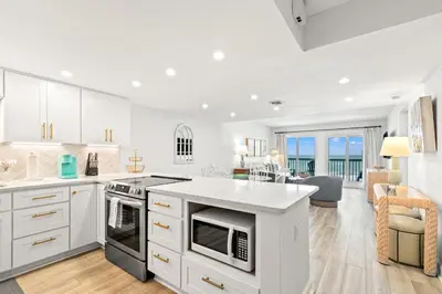 a kitchen with white cabinets and an island with a counter top at Pinnacle Port C1-401 in Carillon Beach