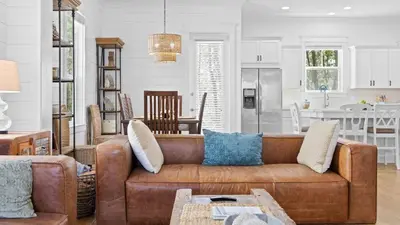 a living room with a brown couch and a kitchen at Near Inlet Beach AccessLake Powell Pool Patio Lounge GDay 30A by AvantStay in Inlet Beach