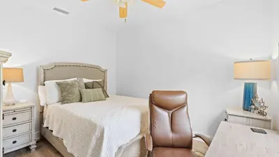 a bedroom with a bed and a brown chair at Near Inlet Beach AccessLake Powell Pool Patio Lounge GDay 30A by AvantStay in Inlet Beach