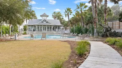 a house with a swimming pool and a wooden walkway at Near Inlet Beach AccessLake Powell Pool Patio Lounge GDay 30A by AvantStay in Inlet Beach