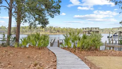 a wooden path leading to a lake with a bridge at Near Inlet Beach AccessLake Powell Pool Patio Lounge GDay 30A by AvantStay in Inlet Beach