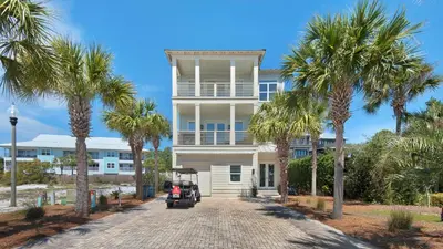 a white house with palm trees in front of it at The Bee's Knees in Santa Rosa Beach