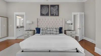 a white bedroom with a large bed and two lamps at The Bee's Knees in Santa Rosa Beach