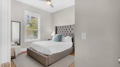 a white bedroom with a bed and a window at The Bee's Knees in Santa Rosa Beach