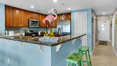 a kitchen with a counter with a bird on the island at Palazzo 806 in Panama City Beach