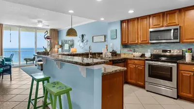 a kitchen with wooden cabinets and a view of the ocean at Palazzo 806 in Panama City Beach