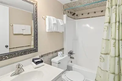 a bathroom with a sink and a toilet and a mirror at Pinnacle Port, C1-303 in Panama City Beach
