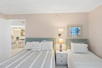 a bedroom with two beds and a lamp at Pinnacle Port, C1-303 in Panama City Beach