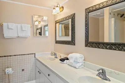 a white bathroom with a sink and a mirror at Pinnacle Port, C1-303 in Panama City Beach