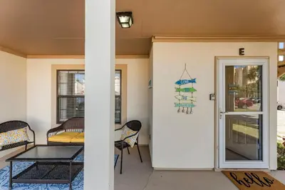 a patio with a table and chairs and a door at Condo w/beach, pools, tennis, shuffleboard, more! in Panama City Beach