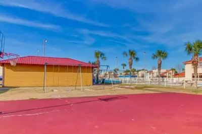 a basketball court in front of a building with palm trees at Condo w/beach, pools, tennis, shuffleboard, more! in Panama City Beach