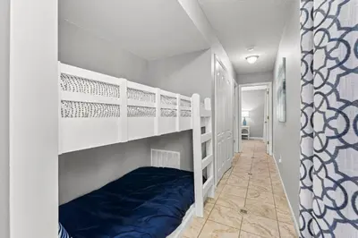 a room with two bunk beds and a hallway at Condo w/beach, pools, tennis, shuffleboard, more! in Panama City Beach