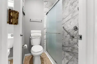 a bathroom with a toilet and a glass shower at Condo w/beach, pools, tennis, shuffleboard, more! in Panama City Beach