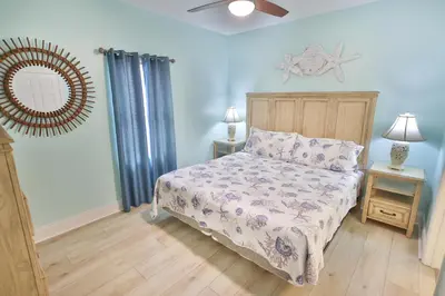 a bedroom with a bed and a mirror on the wall at Lake Town Charming Condo Steps from the Beach in Panama City Beach