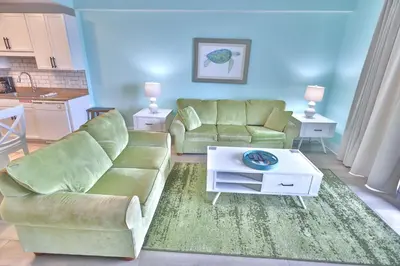 a living room with a couch and a table at Lake Town Charming Condo Steps from the Beach in Panama City Beach