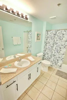 a bathroom with a sink and a toilet and a shower at Lake Town Charming Condo Steps from the Beach in Panama City Beach