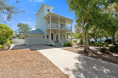 a white house with a balcony and a driveway at Ocean Glory 30A in Inlet Beach