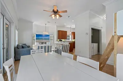 a dining room and living room with a white table and chairs at Ocean Glory 30A in Inlet Beach