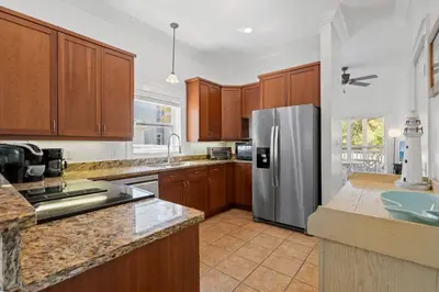 a kitchen with wooden cabinets and a stainless steel refrigerator at Ocean Glory 30A in Inlet Beach
