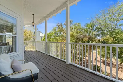 a porch with a white chair and a view of the beach at Ocean Glory 30A in Inlet Beach