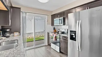 a kitchen with a stainless steel refrigerator at PCB Group-Friendly Duplex w Pool Backyard Lounge 2 Kitchens in Panama City Beach