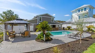 a backyard with a swimming pool and a house at PCB Group-Friendly Duplex w Pool Backyard Lounge 2 Kitchens in Panama City Beach