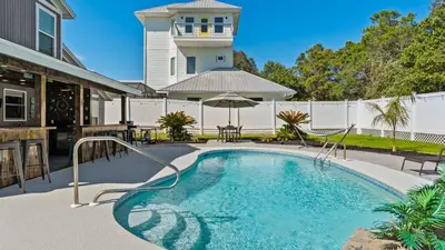 a swimming pool in the backyard of a house at PCB Group-Friendly Duplex w Pool Backyard Lounge 2 Kitchens in Panama City Beach