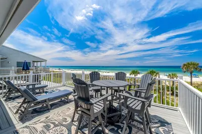 a balcony with tables and chairs and the beach at Beachside West Villa #2 by Emerald Coast Retreats in Panama City Beach