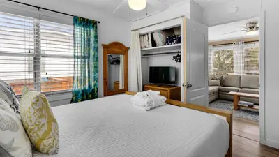 a bedroom with a bed and a living room at Coastal Charm in Santa Rosa Beach