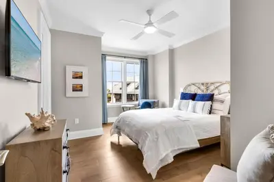 a white bedroom with a bed and a window at Casa Del Oro Penthouse at Barrett Square - Downtown Rosemary Beach Pool &Hot Tub Access in Rosemary Beach