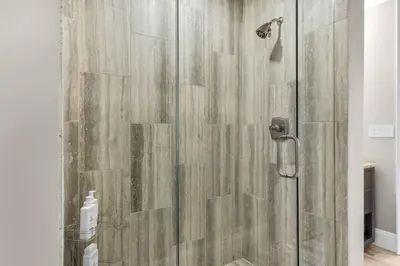 a shower with a glass door in a bathroom at Casa Del Oro Penthouse at Barrett Square - Downtown Rosemary Beach Pool &Hot Tub Access in Rosemary Beach
