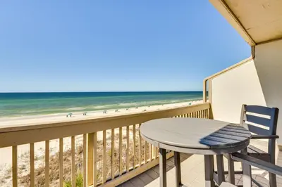 a table and chairs on a balcony with the beach at Steps to Sand Condo with Pool in Panama City Beach in Panama City Beach