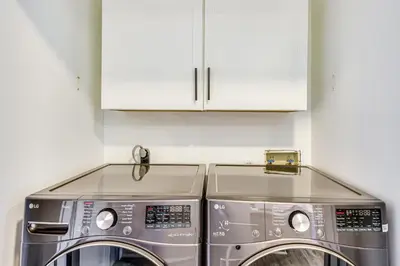 a washer and dryer in a kitchen with white cabinets at Steps to Sand Condo with Pool in Panama City Beach in Panama City Beach
