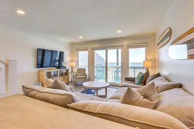 a living room with a couch and a tv at Steps to Sand Condo with Pool in Panama City Beach in Panama City Beach