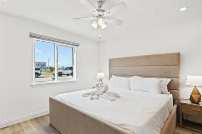 a bedroom with a bed with a ceiling fan and a window at Ocean Breeze 5A in Panama City Beach