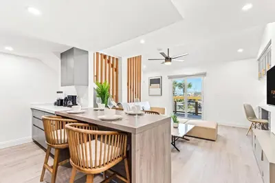 a kitchen and living room with a counter and chairs at Ocean Breeze 5D in Panama City Beach