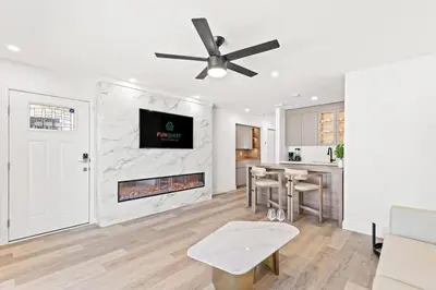 a living room with a fireplace and a ceiling fan at Ocean Breeze 5B in Panama City Beach