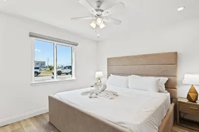 a bedroom with a bed with a ceiling fan and a window at Ocean Breeze 5B in Panama City Beach