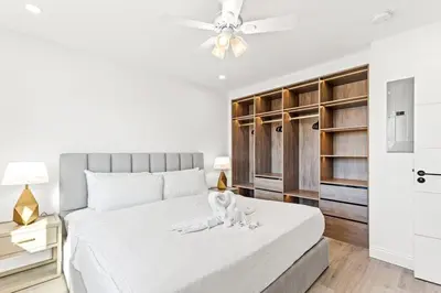 a bedroom with a white bed with a dog on it at Ocean Breeze 5C in Panama City Beach