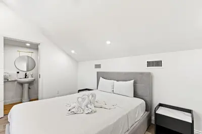 a white bedroom with a large bed with a mirror at Ocean Breeze 5C in Panama City Beach