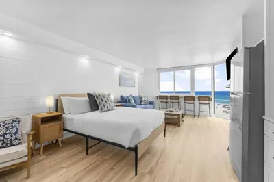 a bedroom with a bed and a couch and the ocean at Beach Front Ocean View Condo - Top of the Gulf 521 in Panama City Beach