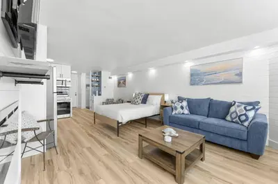 a living room with a blue couch and a table at Beach Front Ocean View Condo - Top of the Gulf 521 in Panama City Beach