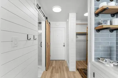 a bathroom with white cabinets and a white door at Beach Front Ocean View Condo - Top of the Gulf 521 in Panama City Beach