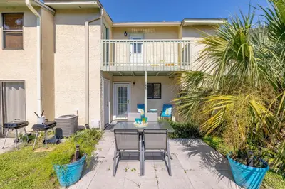 a patio with a table and chairs in front of a house at Captain's Quarters at Gulf Highlands Beach Resort in Panama City Beach