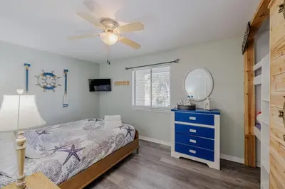 a bedroom with a bed and a mirror and a ceiling fan at Captain's Quarters at Gulf Highlands Beach Resort in Panama City Beach
