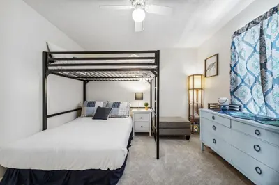 a bedroom with a bunk bed and a dresser and a bed at Beach Walkers by Beach Haven Vacation Rentals in Panama City Beach