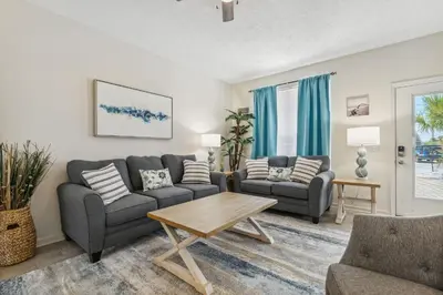 a living room with two couches and a table at Beach Walkers by Beach Haven Vacation Rentals in Panama City Beach