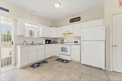 a kitchen with white cabinets and a white refrigerator at Beach Walkers by Beach Haven Vacation Rentals in Panama City Beach