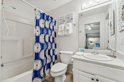 a white bathroom with a toilet and a sink at Beach Walkers by Beach Haven Vacation Rentals in Panama City Beach